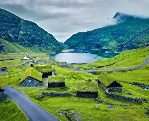 View from flying drone. Green summer scene of Saksun village with typical turf-top houses and Saksunar Kirkja
