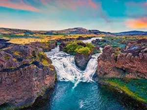 View from flying drone. Majestic summer sunset on Hjalparfoss Waterfall