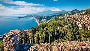 View from flying drone. Sunny morning view of Taormina town and Etna volcano on background