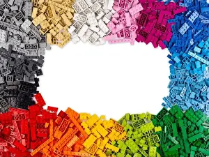 Construct Prints: top view of frame of many various colorful rainbow colored stackable plastic toy bricks with copy space isolated