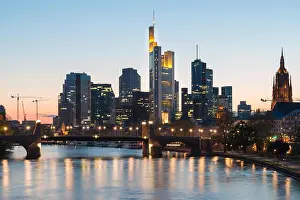 View of Frankfurt am Main skyline at dusk along Main river with cruise ship in Frankfurt, Germany