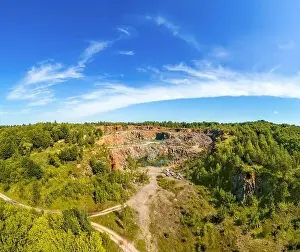 View from above of granite quarry in the forest. Mountain landscape on a summer sunny day