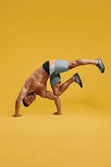 Bodybuilding Prints: Front view of handsome muscular guy standing upside down