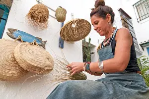 Weaving Prints: Side view of Hispanic woman weaving a basket with esparto fibers