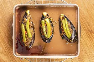 Eggplant Prints: Top view of hot delicious turkey stuffed eggplants - karniyarik in golden tray metal ovenware on metal cooling rack