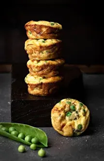 Potatoes Prints: Side view still life of stacked pea muffins against dark background