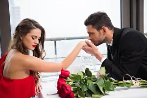 Bouquet Of Flowers Prints: side view of man kissing girlfriends hand during date on st valentine day in restaurant