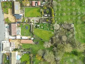 Aerial Cityscape Prints: Top down view of a mixture of old and modern houses and bungalows seen at the edge of an East Anglian village
