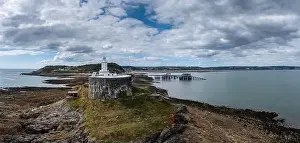 View of the Mumbles headland with the historic lighthouse and piers in Swansea Bay