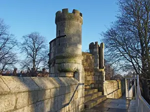 Surrounding Prints: a view along the pedestrian walkway on historic medieval city walls in york showing one of the small defensive towers