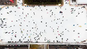 Ice Skating Prints: Top view of people skating on large open air ice rink on winter day