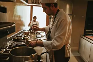 Stove Prints: Side view of a person standing at the stove and cooking in the restaurant
