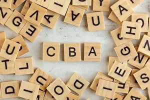 Scattered Prints: Top down view, pile of square wooden blocks with letters CBA (stands for Cost Benefit Assessment) on white board
