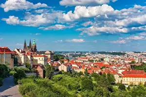 View of Prague featuring historic castle and vibrant rooftops on a sunny day in summer