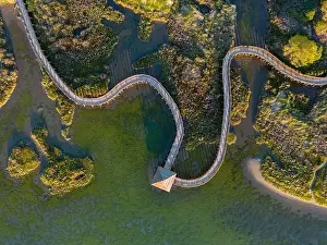 Top view of sea with wooden walkway - Aerial top view of wooden bridge pathway over marshy river with vegetation