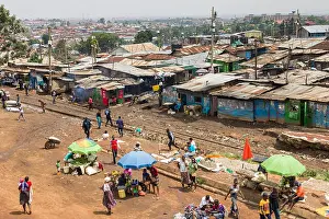 Nairobi Prints: View of a section of Kibera slum showing makeshift shack housing and residents going about daily life