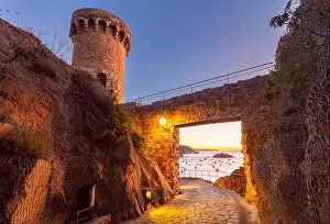 Sea View Prints: View of a tower and stone gateway of Tossa de Mar Castle overlooking the Mediterranean Sea at sunrise