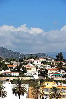 Whitewashed Prints: View of villas and apartments on the hillside with mountains to the rear