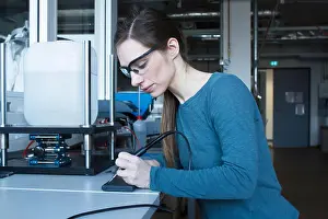 Goggles Prints: Side view of woman in workshop wearing safety goggles using soldering iron