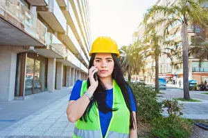 Vest Prints: front view of young caucasian female construction worker wearing yellow safety helmet