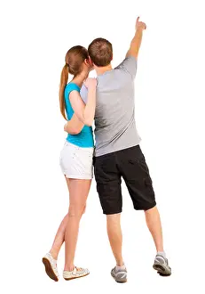 Honeymoon Prints: Back view of young couple pointing at wall (woman and man)