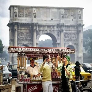 Wish You Were Here Collection: Vintage Rome 1970s, couple having fun by street ice-cream seller in front of triumphal arch of