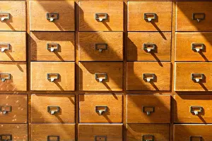 Side By Side Prints: A vintage unit of small drawers / chest of drawers with numerous drawers perhaps use for record keeping cards