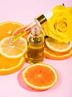 Aromatherapy Prints: Vitamin C serum bottle with dropper on pink background with orange citrus slices