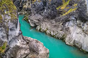 Cliffside Prints: A vivid turquoise river flows between steep rocky canyon walls