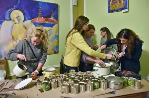 Volunteer Prints: Volunteers melt paraffin and fill prepared jars with it to make trench candles