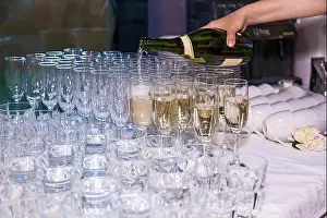 Waiter Prints: The waiter pours champagne into glasses from a bottle in a restaurant. Catering, banquet