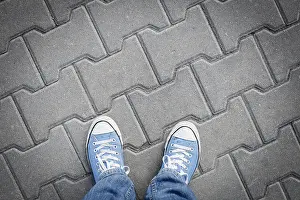 Sneakers Prints: On a walk - wearing sneakers, top view on concrete pavement and blue shoes, vignette image