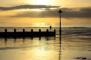 Walkers Prints: Walkers couple on Borth Beach at sunset Ceredigion Wales Cymru UK GB