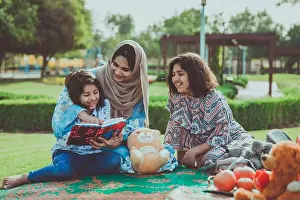 Abaya Prints: Warm lifestyle image of a mother with her two daughters enjoying time together at a Dubai park