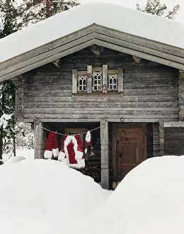Washing line with Santa Claus clothes hanging outdoors in the snow.