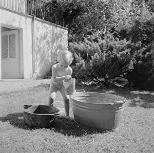 Water fun Girl playing with a pool of water in the garden of the Bachmann house Date: 1960 Location: Bad Mergentheim, Baden-Württemberg, Germany