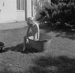 Water fun Girl playing with a pool of water in the garden of the Bachmann house Date: 1960 Location: Bad Mergentheim