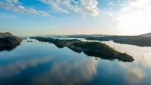Mountain Ridge Prints: The water is like a mirror, the blue sky with small clouds is reflected in it