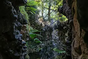 Sintra Prints: Water trickles down rocky cliffs into a peaceful pond, surrounded by vibrant foliage