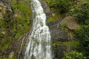 Flowing Water Prints: Waterfall cascading down a rocky cliff surrounded by lush green vegetation