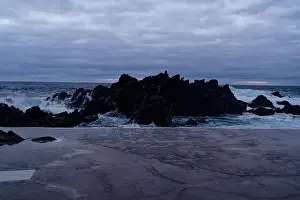 Moody Sky Prints: Waves crash against volcanic rocks under a dramatic sky at Porto Moniz natural pools