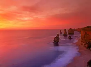 Red Rock Prints: Waves along the shore with The Twelve Apostles at sunset in Victoria Australia