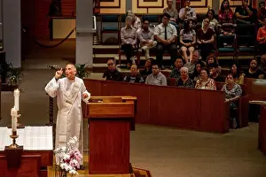 45 50 Years Prints: Wearing a white robe, an enthusiastic deacon preaches a sermon in the pulpit of a Catholic church in Tustin