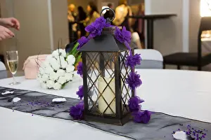 Purple Flowers Prints: Wedding Reception table decorations with a black lantern with candle inside and purple flower trims