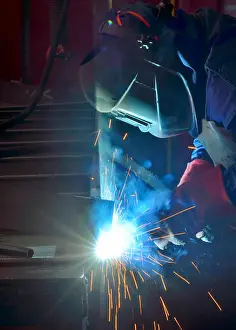 Repairing Prints: welder working with electrode at semi-automatic arc welding in manufacture production plant