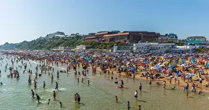 Parasol Prints: West Cliff Beach, Bournemouth, UK - May 24th 2026: Crowd of people in the sea and on the beach during hot weather