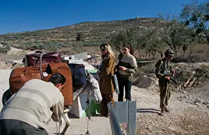 West Bank Prints: Western tourists with donkey overloaded with luggages and soldier on patrol, West Bank
