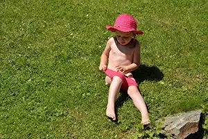 Wet little girl after playing with the water jet in swimsuit