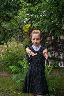 Wet schoolgirl standing in the rain. teenager in school uniform in spring or warm autumn. Girl 5th grade. Hair coloring