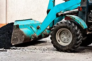 Scoop Prints: The wheel bulldozer works at asphalt laying